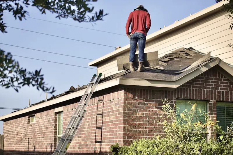 Professional roofer working on a residential roof in North Country Knolls